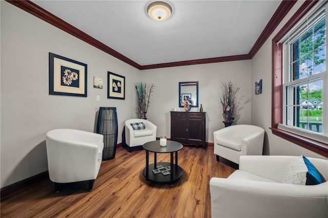 sitting room with ornamental molding, healthy amount of natural light, baseboards, and wood finished floors