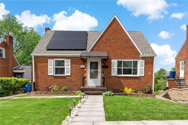 3652 Oakleaf Rd, Baldwin Boro, PA 15227 - tudor house featuring brick siding, roof with shingles, roof mounted solar panels, and a front lawn