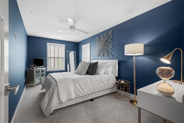 carpeted bedroom with baseboards and a ceiling fan