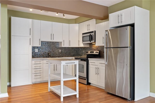 5708 Walnut Unit B2, Shadyside, PA 15232 - kitchen featuring stainless steel appliances, white cabinets, decorative backsplash, and light wood-style flooring