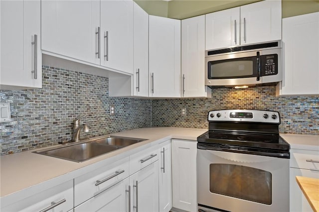 5708 Walnut Unit B2, Shadyside, PA 15232 - kitchen with appliances with stainless steel finishes, a sink, light countertops, white cabinets, and tasteful backsplash