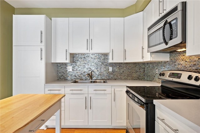 5708 Walnut Unit B2, Shadyside, PA 15232 - kitchen with stainless steel appliances, light countertops, a sink, white cabinets, and tasteful backsplash