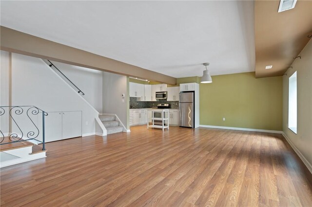 5708 Walnut Unit B2, Shadyside, PA 15232 - unfurnished living room featuring stairway, light wood-type flooring, and baseboards
