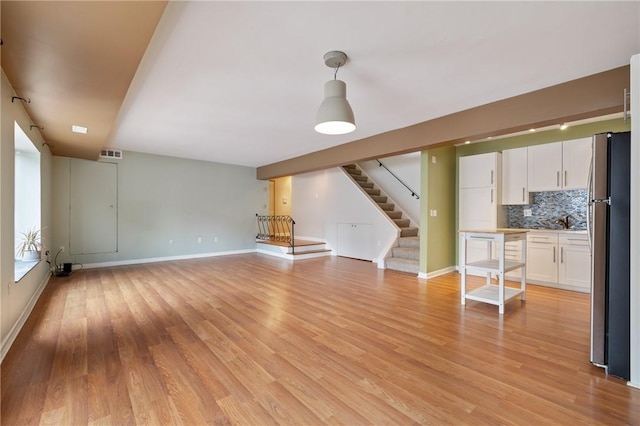 5708 Walnut Unit B2, Shadyside, PA 15232 - unfurnished living room with stairs, light wood-style floors, and baseboards