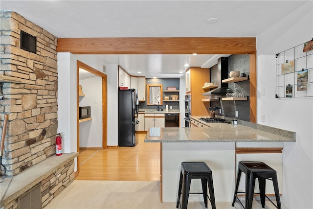 147 Crimson Oak Rd, Jefferson Twp Som, PA 15501 - kitchen with black appliances, open shelves, a peninsula, wall chimney exhaust hood, and light stone counters