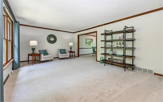 sitting room with crown molding, light colored carpet, and baseboards