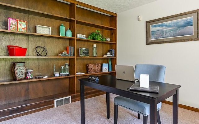 home office with carpet, baseboards, and a textured ceiling