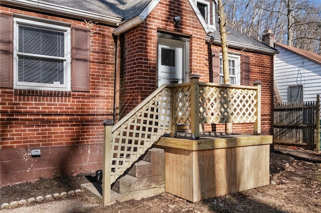 2357 Pitcairn Rd, Monroeville, PA 15146 - view of exterior entry featuring brick siding, fence, crawl space, and roof with shingles