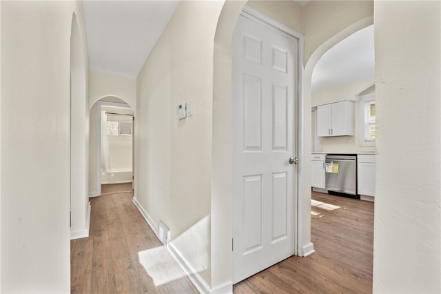 2357 Pitcairn Rd, Monroeville, PA 15146 - hall with arched walkways, light wood-type flooring, and baseboards