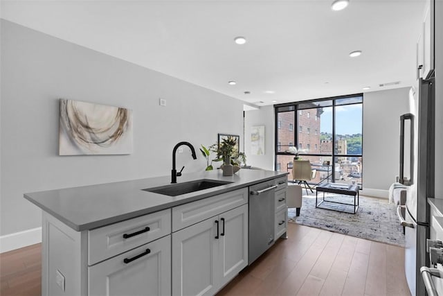 350 Oliver Ave Unit 1203, Downtown Pgh, PA 15222 - kitchen featuring stainless steel appliances, a sink, wood finished floors, white cabinets, and expansive windows