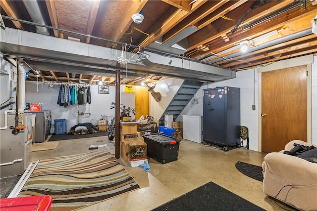 unfinished below grade area featuring refrigerator, washer / dryer, and stairs