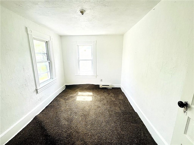 128 Cessna Hill Rd, Jenner Twp, PA 15531 - empty room featuring baseboards, baseboard heating, dark colored carpet, a textured ceiling, and a textured wall