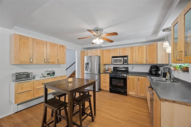 426 Oliver Dr, White Oak, PA 15131 - kitchen featuring stainless steel appliances, a sink, light brown cabinetry, a baseboard radiator, and dark countertops