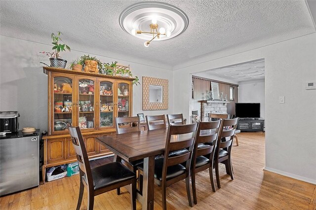 426 Oliver Dr, White Oak, PA 15131 - dining area featuring a textured ceiling, light wood-style floors, a chandelier, and baseboards