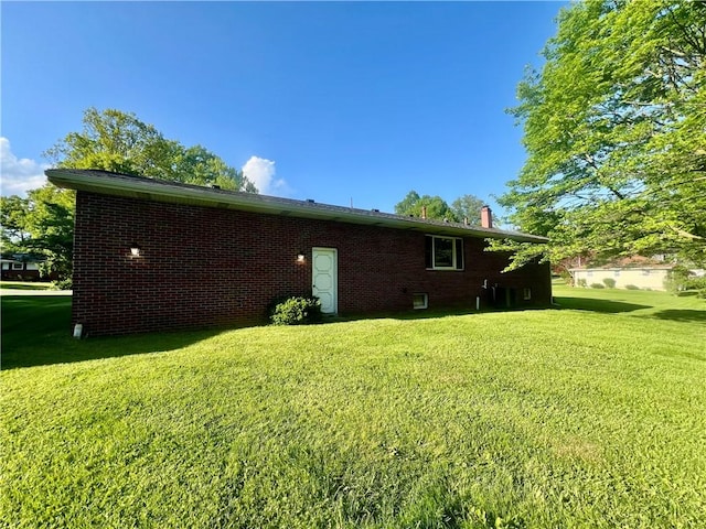 view of property exterior with a lawn and brick siding