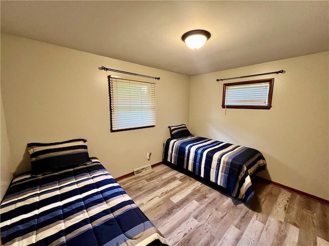 bedroom featuring wood finished floors and baseboards