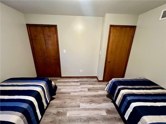 bedroom with light wood-type flooring and a closet