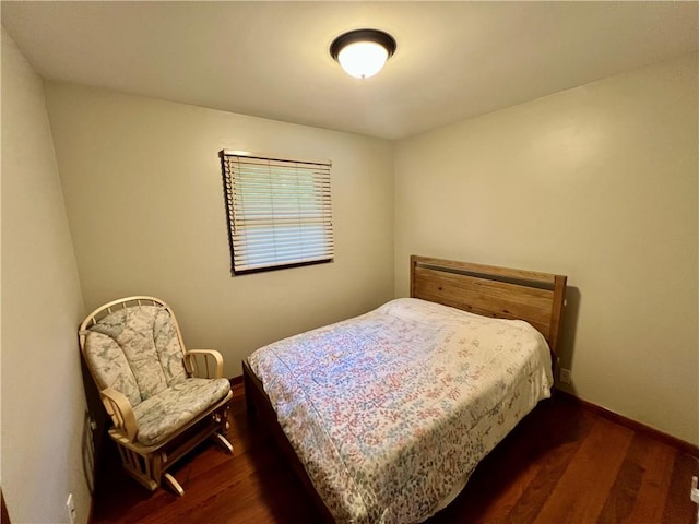bedroom with dark wood finished floors and baseboards