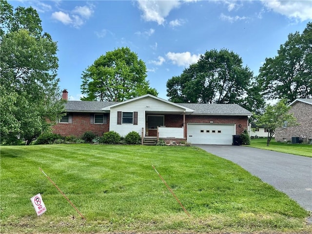 ranch-style home featuring brick siding, an attached garage, a chimney, driveway, and a front yard