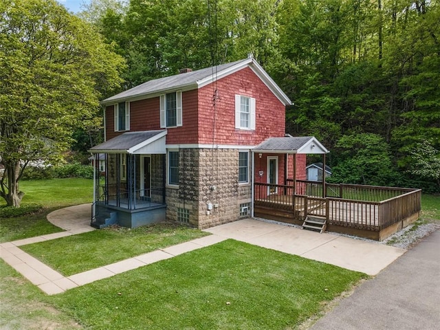 view of front of property with a front yard, a deck, and a chimney