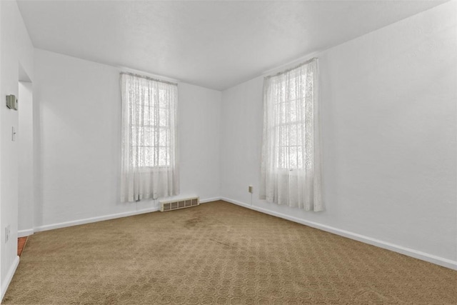 empty room featuring carpet and baseboards