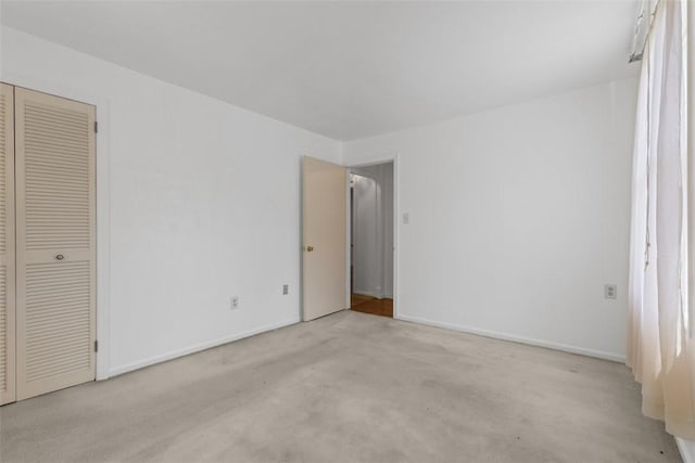 unfurnished bedroom featuring carpet flooring, baseboards, and a closet