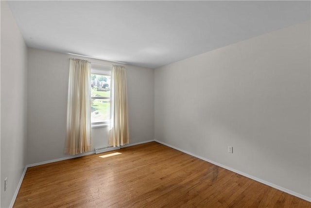 unfurnished room featuring wood finished floors and baseboards
