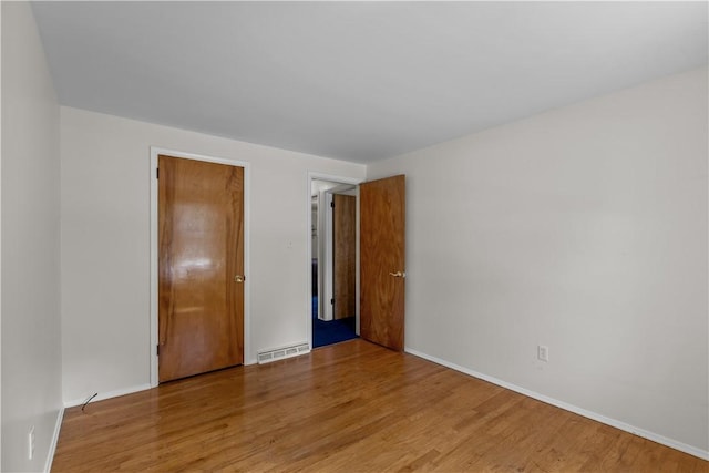 empty room with wood finished floors and baseboards