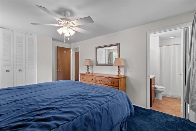 carpeted bedroom with a closet, connected bathroom, ceiling fan, and baseboards