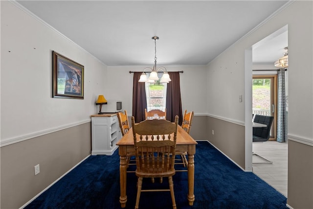 dining space with a chandelier, baseboards, ornamental molding, and carpet