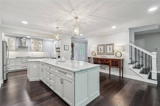 1231 Nicklaus Way W, Deer, PA 15044 - kitchen with wall chimney range hood, stainless steel appliances, light stone countertops, white cabinetry, and a sink