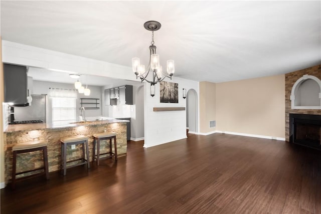 239 Mountain Dr, Carnegie, PA 15106 - kitchen with a peninsula, a fireplace, a chandelier, a sink, and dark wood-type flooring