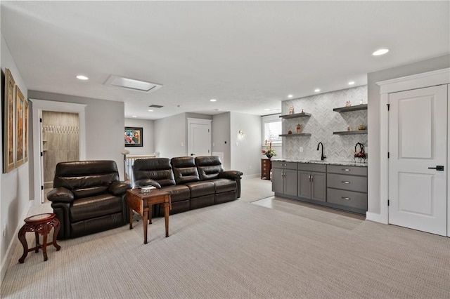 living area with wet bar, light colored carpet, baseboards, and recessed lighting
