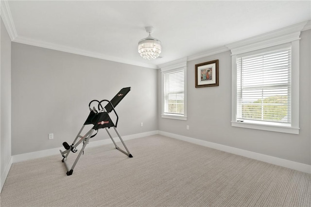 exercise room with ornamental molding, carpet, a chandelier, and baseboards