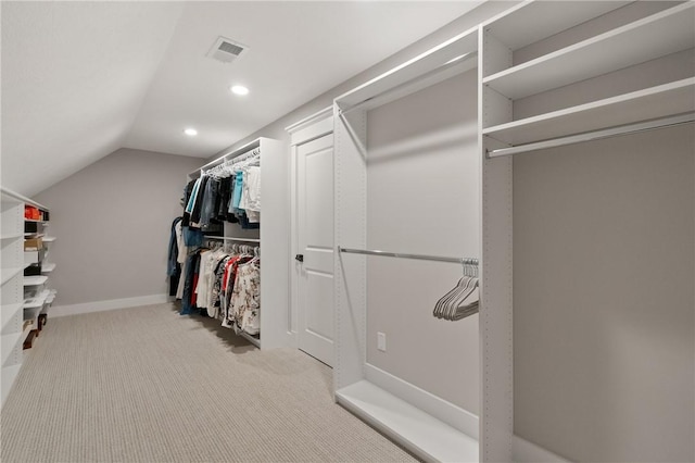 walk in closet featuring carpet flooring and vaulted ceiling