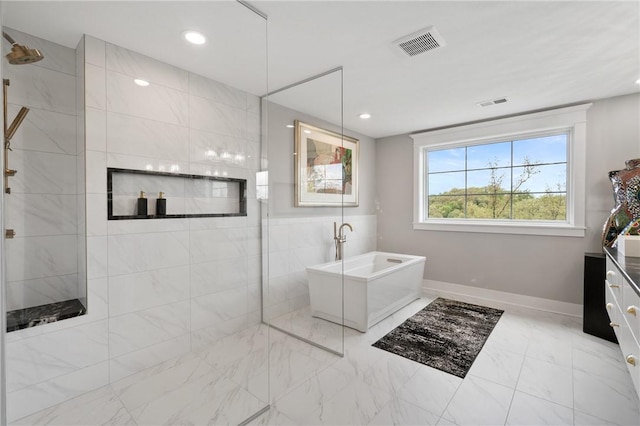 full bathroom with a freestanding tub, marble finish flooring, walk in shower, baseboards, and recessed lighting