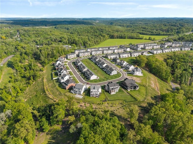 aerial view of property's location featuring a heavily wooded area and nearby suburban area