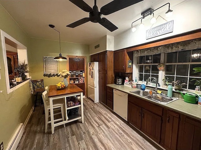 kitchen featuring white appliances, a sink, a baseboard heating unit, wood finished floors, and a ceiling fan
