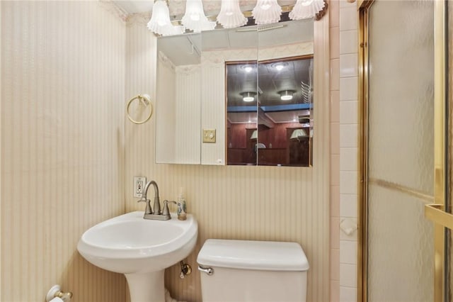4782 Barone Dr, Whitehall, PA 15227 - bathroom featuring toilet, wallpapered walls, a sink, and a shower with door