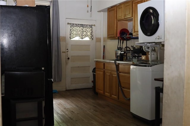 518 Middle Ave, Wilmerding, PA 15148 - kitchen featuring freestanding refrigerator, estacked washer and dryer, dark wood-style floors, tile counters, and brown cabinetry