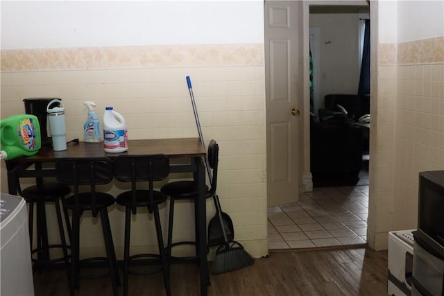 518 Middle Ave, Wilmerding, PA 15148 - dining space with tile walls, wood finished floors, and a wainscoted wall