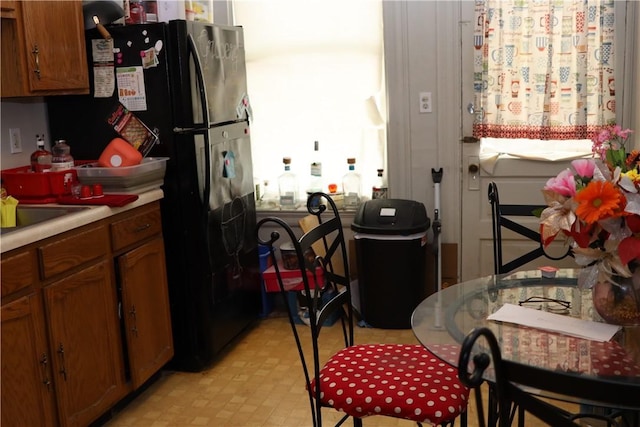 518 Middle Ave, Wilmerding, PA 15148 - kitchen featuring brown cabinetry, light flooring, light countertops, and freestanding refrigerator