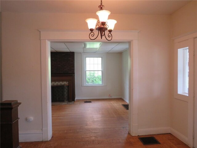 802 Howard St, Monongahela, PA 15063 - unfurnished dining area with wood finished floors, a fireplace, and a chandelier