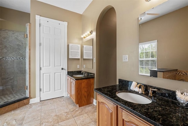 bathroom with a shower stall, two vanities, and tile patterned flooring