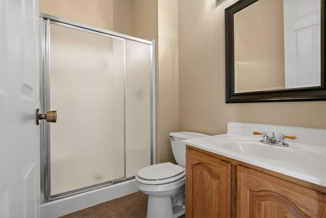 bathroom featuring tile patterned floors, a shower stall, toilet, and vanity