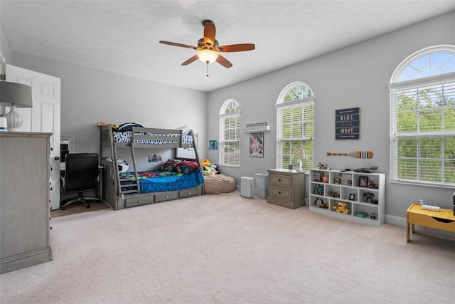 bedroom with an office area, carpet flooring, and a ceiling fan