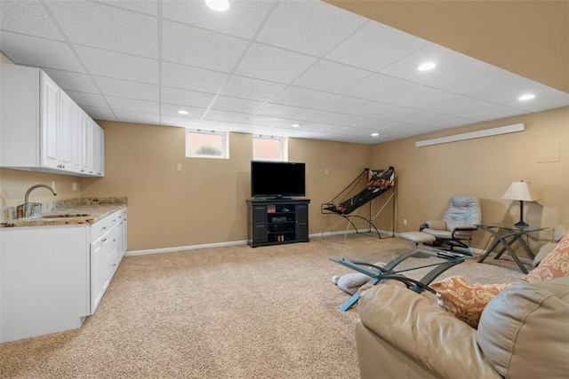 living area with a paneled ceiling, light colored carpet, baseboards, and recessed lighting