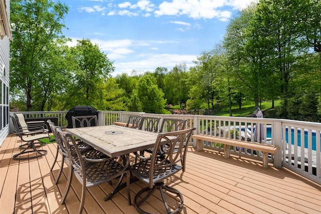 wooden deck featuring outdoor dining space and view of scattered trees