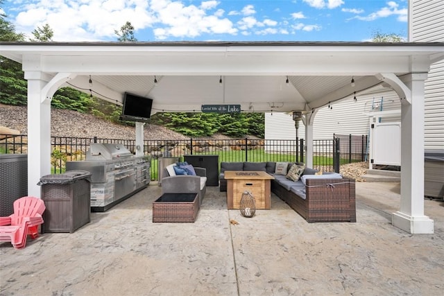 view of patio / terrace featuring an outdoor living space with a fire pit, fence, a gazebo, an outdoor kitchen, and area for grilling