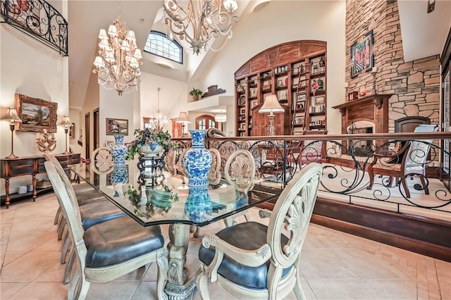tiled dining room featuring a chandelier, a high ceiling, and a fireplace